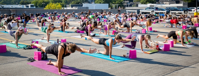 An outdoor large group of people exercising in open area An outdoor large group of people exercising in open area